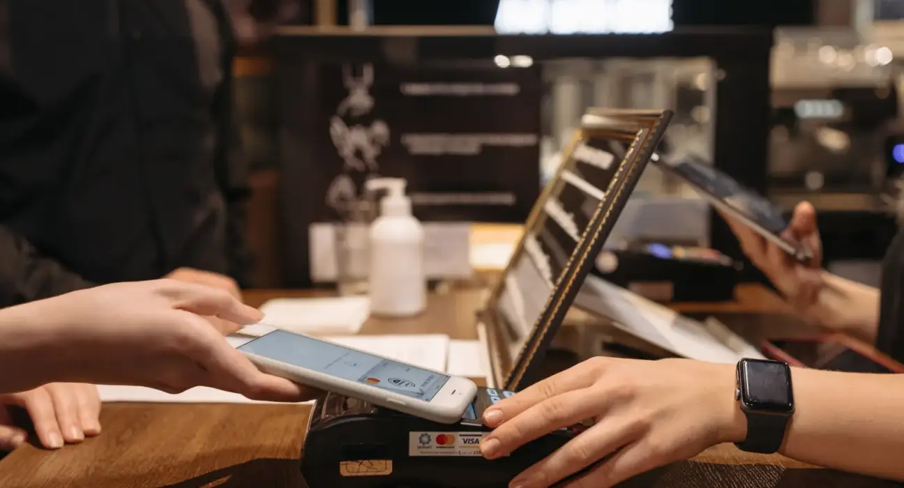 Kundin bezahlt mit einem Smartphone an einem Kartenterminal