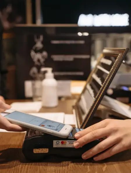 Kundin bezahlt mit einem Smartphone an einem Kartenterminal