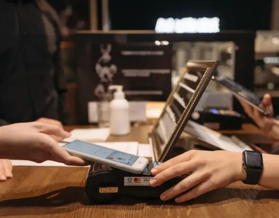 Kundin bezahlt mit einem Smartphone an einem Kartenterminal