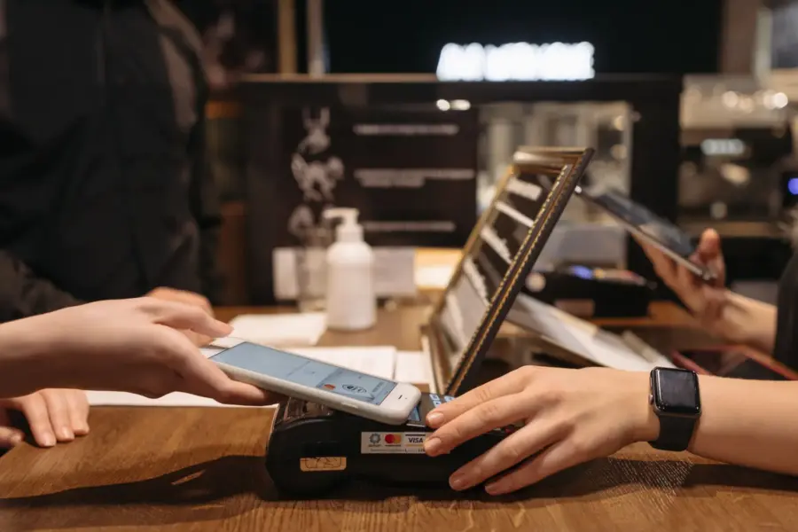 Kundin bezahlt mit einem Smartphone an einem Kartenterminal