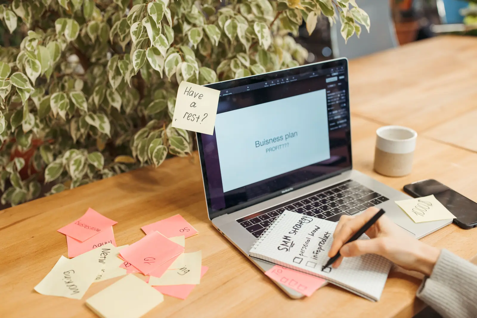 Laptop mit geöffnetem Businessplan und handschriftlichen Notizen