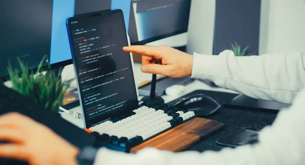 Softwareentwickler prüft Programmcode auf einem Laptop