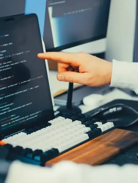 Softwareentwickler prüft Programmcode auf einem Laptop