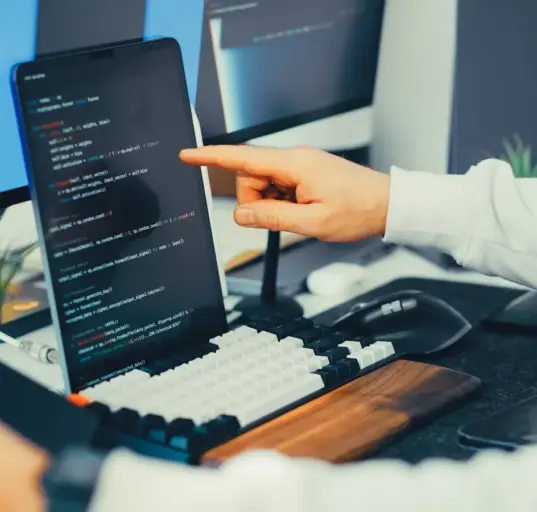 Softwareentwickler prüft Programmcode auf einem Laptop