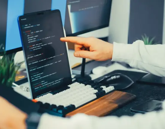 Softwareentwickler prüft Programmcode auf einem Laptop