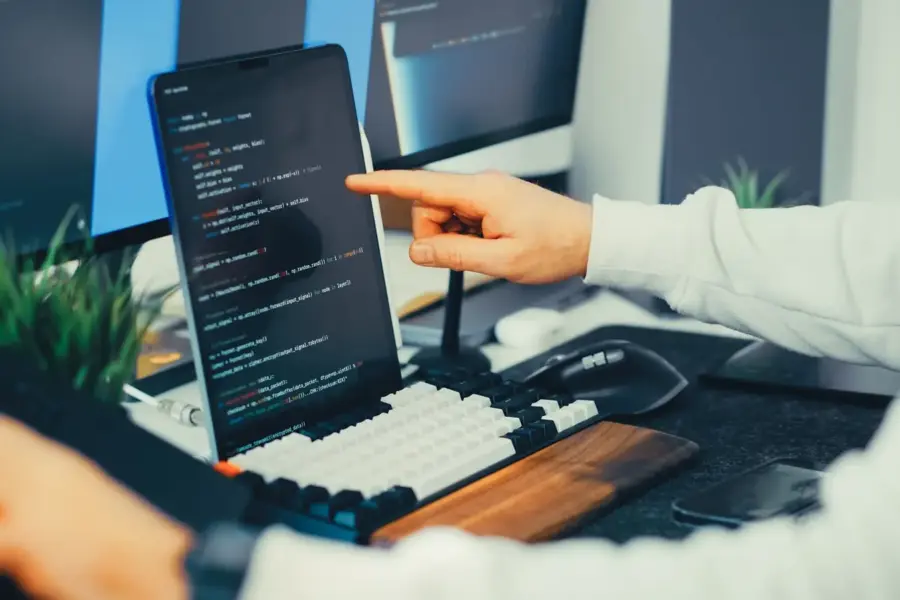 Softwareentwickler prüft Programmcode auf einem Laptop