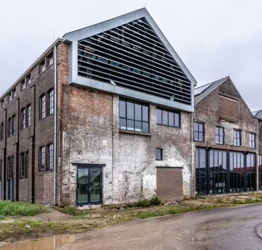 Saniertes ehemaliges Fabrikgebäude mit historischen Backsteinwänden und moderner Fassade