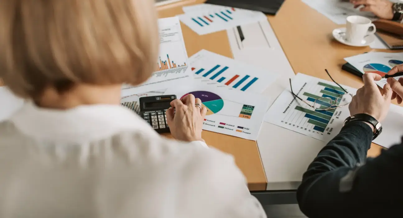 Geschäftsleute prüfen Finanzgrafiken und Berechnungen an einem Tisch