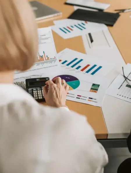 Geschäftsleute prüfen Finanzgrafiken und Berechnungen an einem Tisch