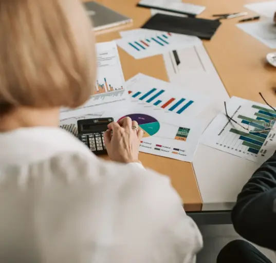 Geschäftsleute prüfen Finanzgrafiken und Berechnungen an einem Tisch