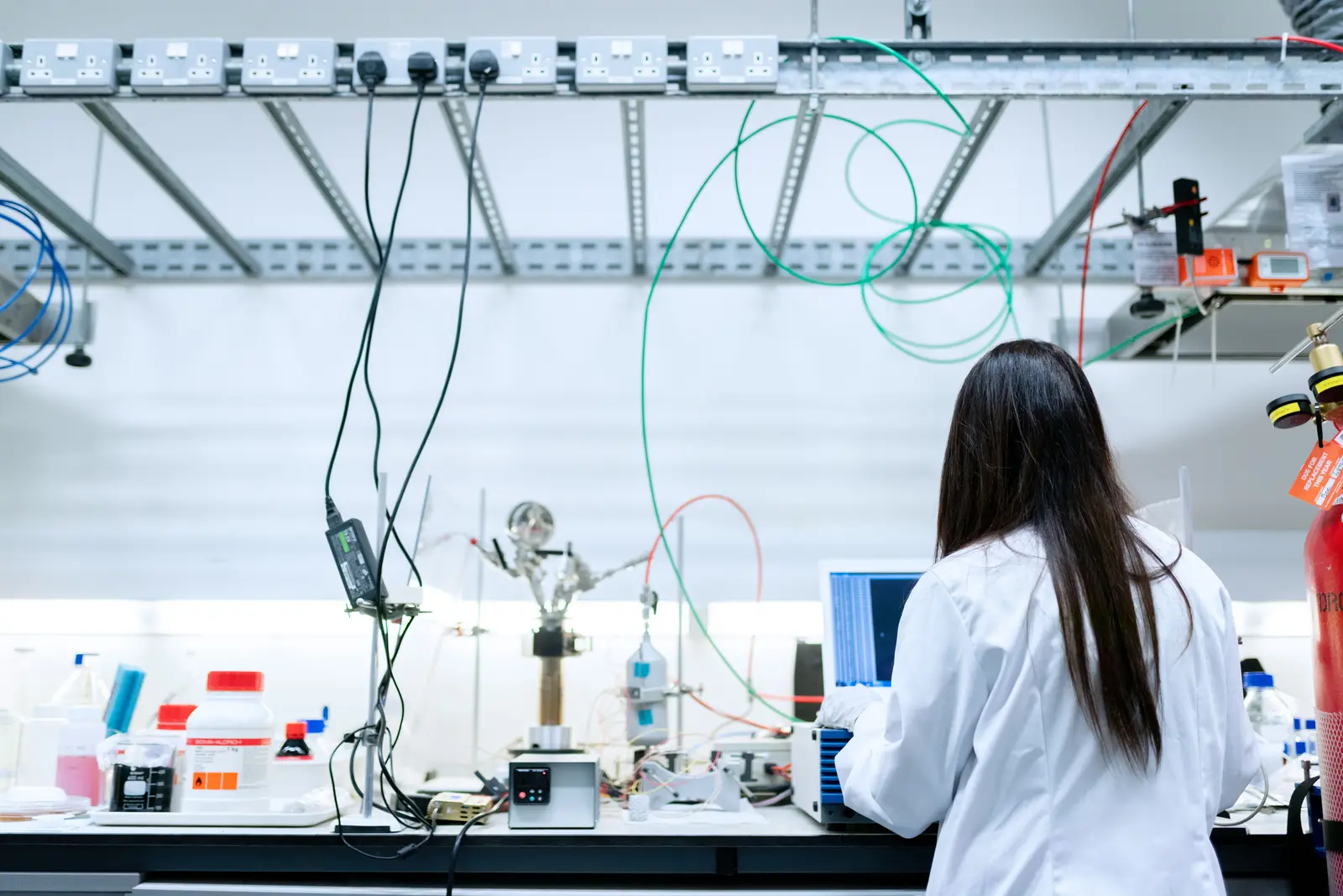 Wissenschaftlerin arbeitet an Messgeräten in einem technischen Forschungslabor