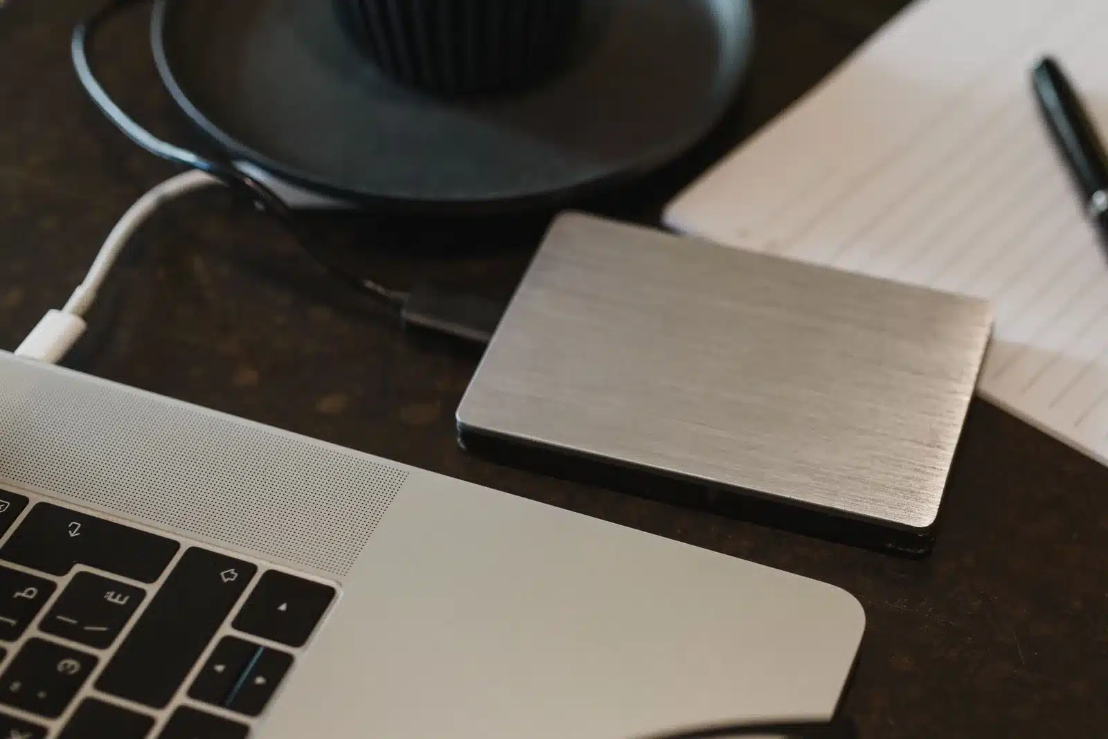 Externe Festplatte ist über ein USB-Kabel mit einem Laptop auf einem Schreibtisch verbunden