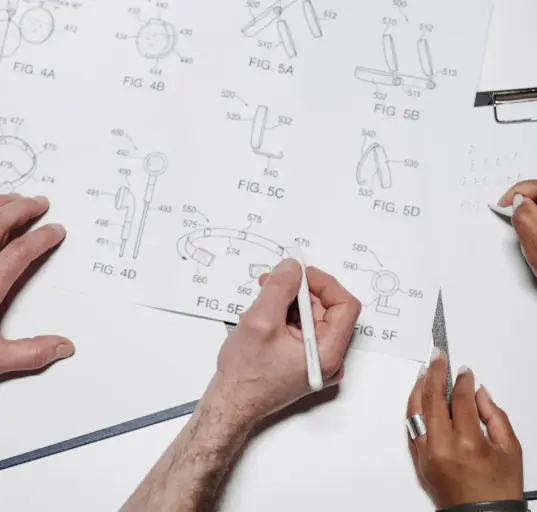 Mehrere Personen arbeiten gemeinsam an technischen Designzeichnungen