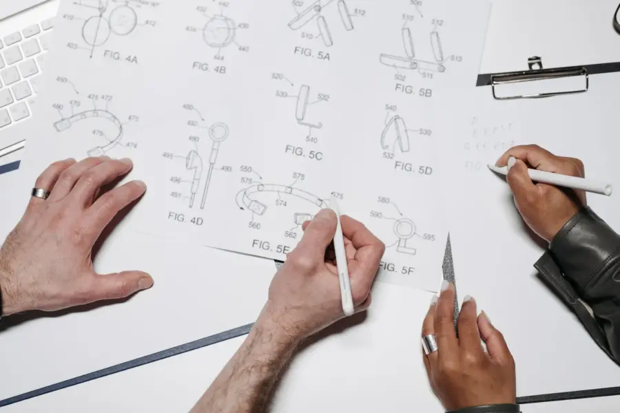 Mehrere Personen arbeiten gemeinsam an technischen Designzeichnungen