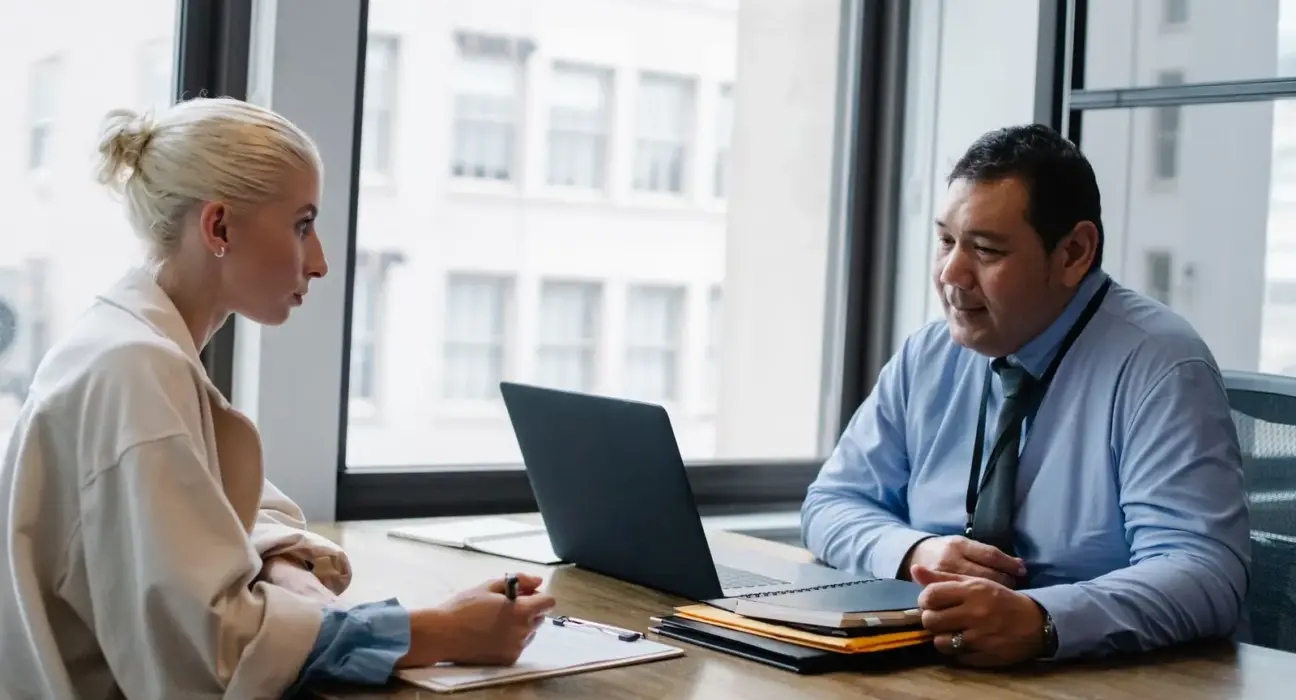 Arbeitgeber und Bewerberin führen ein Vorstellungsgespräch im Büro