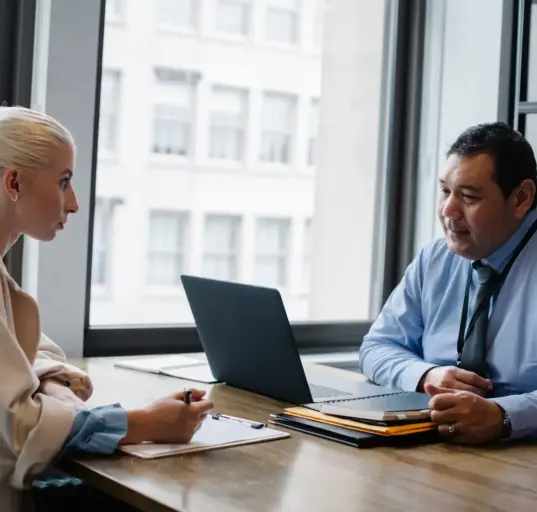 Arbeitgeber und Bewerberin führen ein Vorstellungsgespräch im Büro