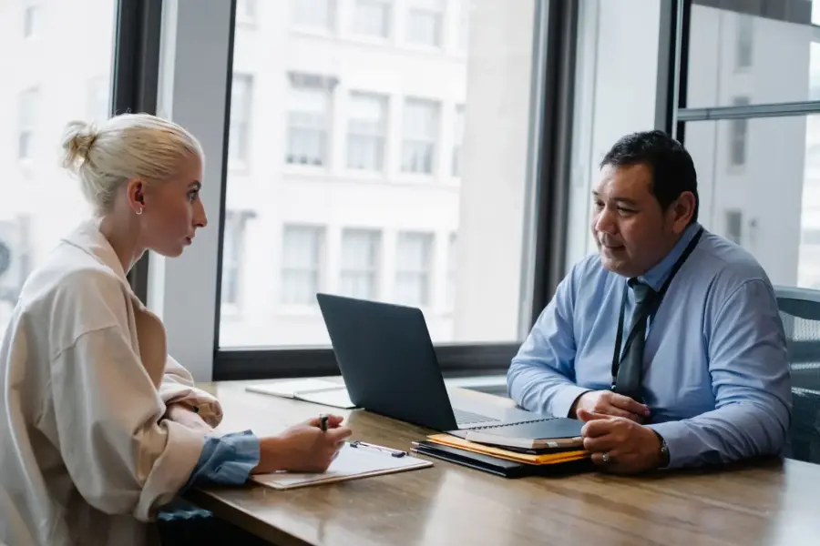Arbeitgeber und Bewerberin führen ein Vorstellungsgespräch im Büro
