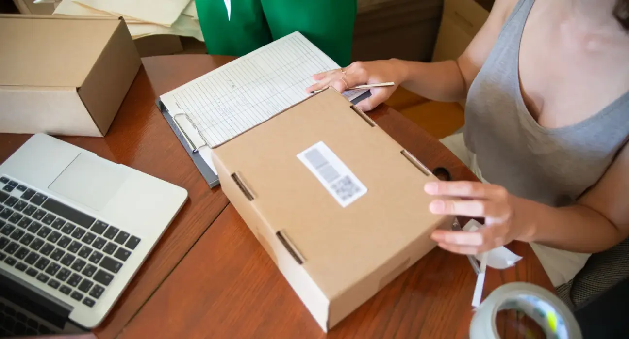 Zwei Mitarbeiterinnen eines kleinen Onlinehandels verpacken Bestellungen in Versandkartons