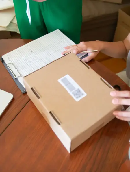 Zwei Mitarbeiterinnen eines kleinen Onlinehandels verpacken Bestellungen in Versandkartons