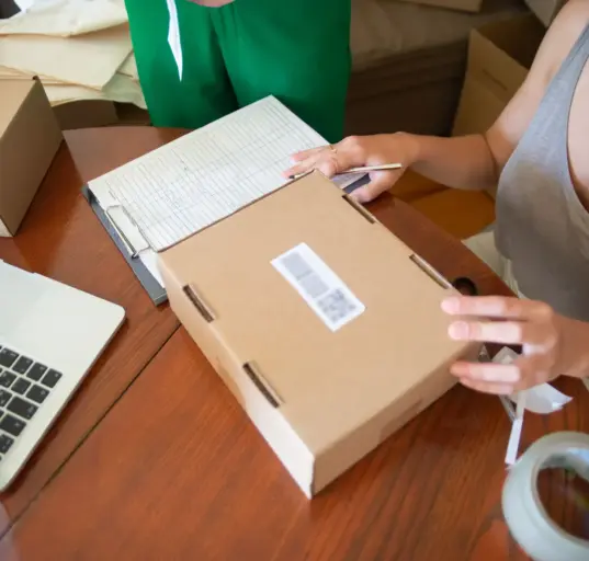 Zwei Mitarbeiterinnen eines kleinen Onlinehandels verpacken Bestellungen in Versandkartons