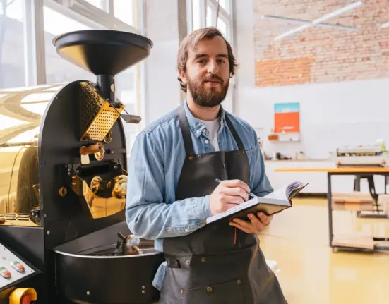 Inhaber einer Kaffeerösterei dokumentiert den Betrieb einer neuen Röstmaschine