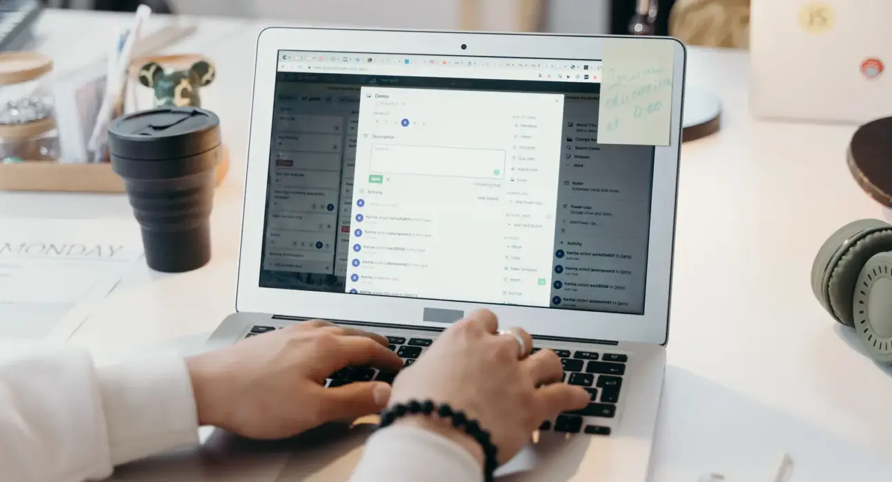 Person arbeitet in einem hellen Büro an einem Laptop