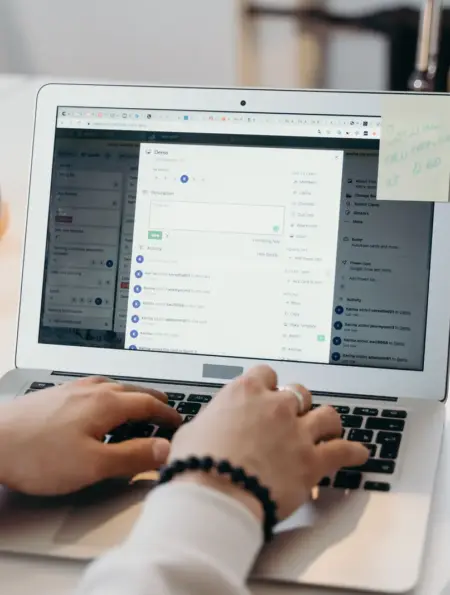 Person arbeitet in einem hellen Büro an einem Laptop