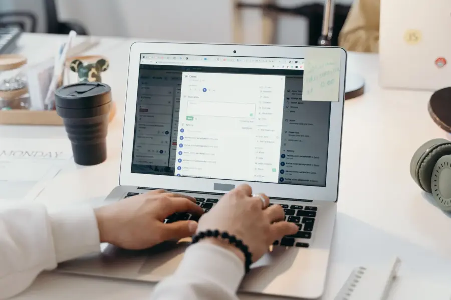 Person arbeitet in einem hellen Büro an einem Laptop