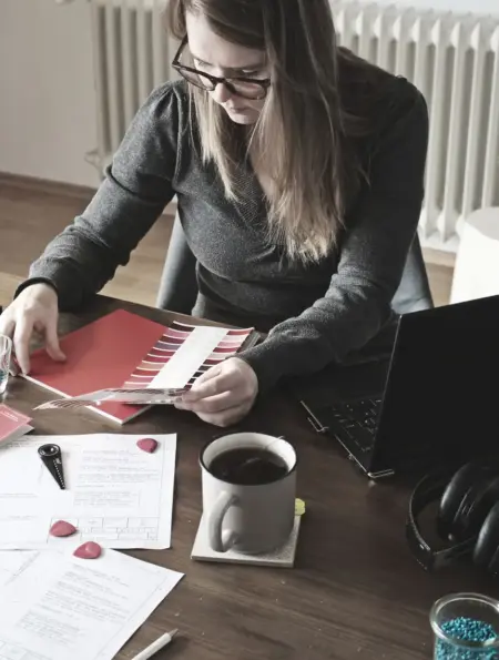 Selbstständige Designerin prüft Farbmuster an ihrem Arbeitsplatz