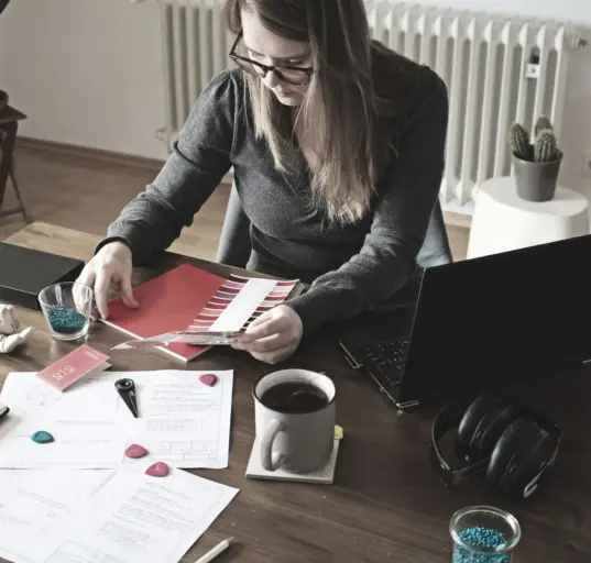 Selbstständige Designerin prüft Farbmuster an ihrem Arbeitsplatz