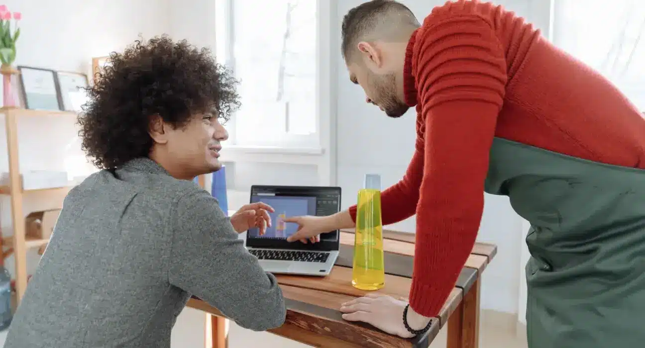 Zwei Mitarbeiter eines kleinen Betriebs besprechen am Laptop ein digitales Produktmodell