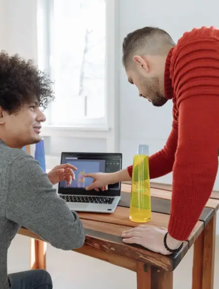 Zwei Mitarbeiter eines kleinen Betriebs besprechen am Laptop ein digitales Produktmodell