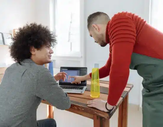 Zwei Mitarbeiter eines kleinen Betriebs besprechen am Laptop ein digitales Produktmodell