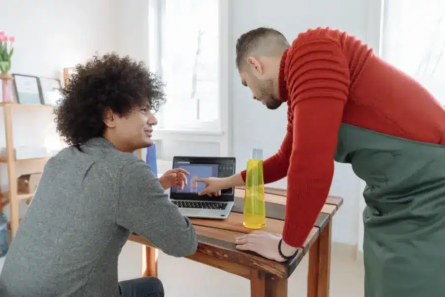 Zwei Mitarbeiter eines kleinen Betriebs besprechen am Laptop ein digitales Produktmodell