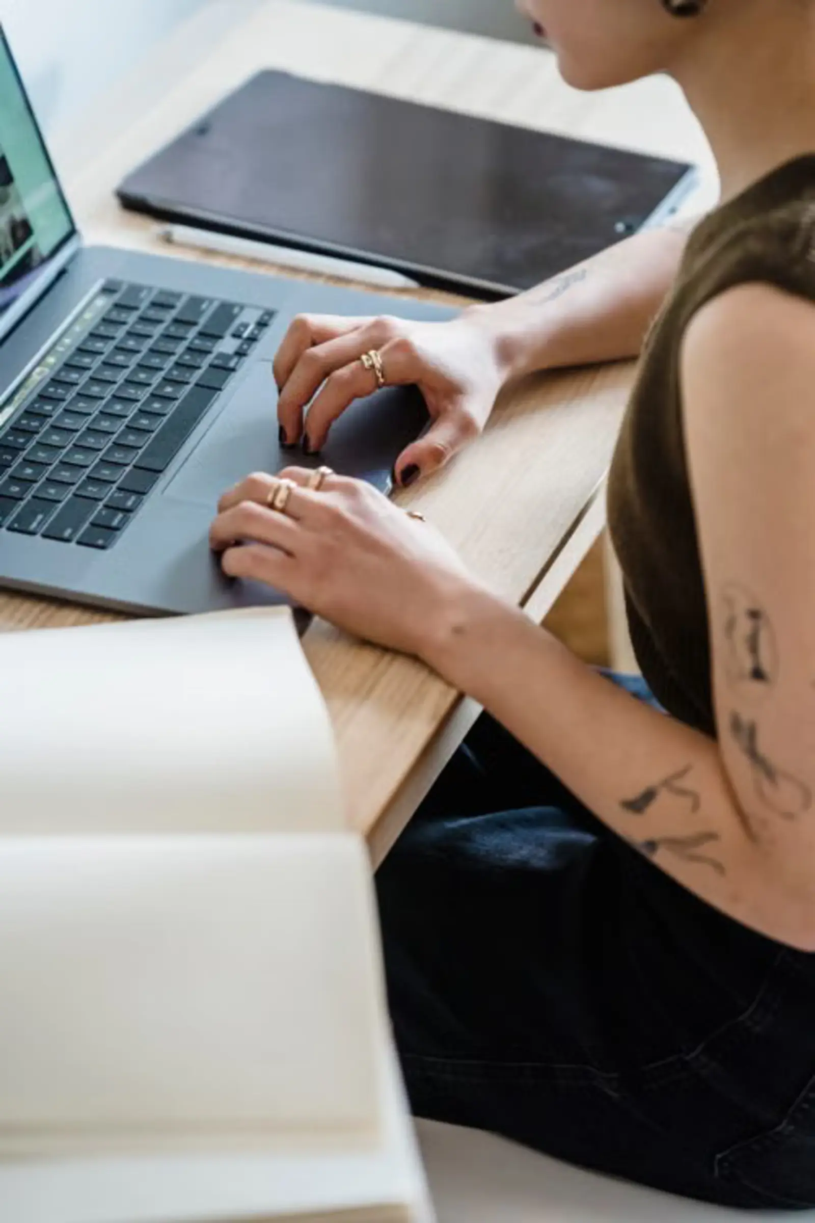Selbstständige arbeitet eigenständig mit Laptop und Notizbuch im Homeoffice