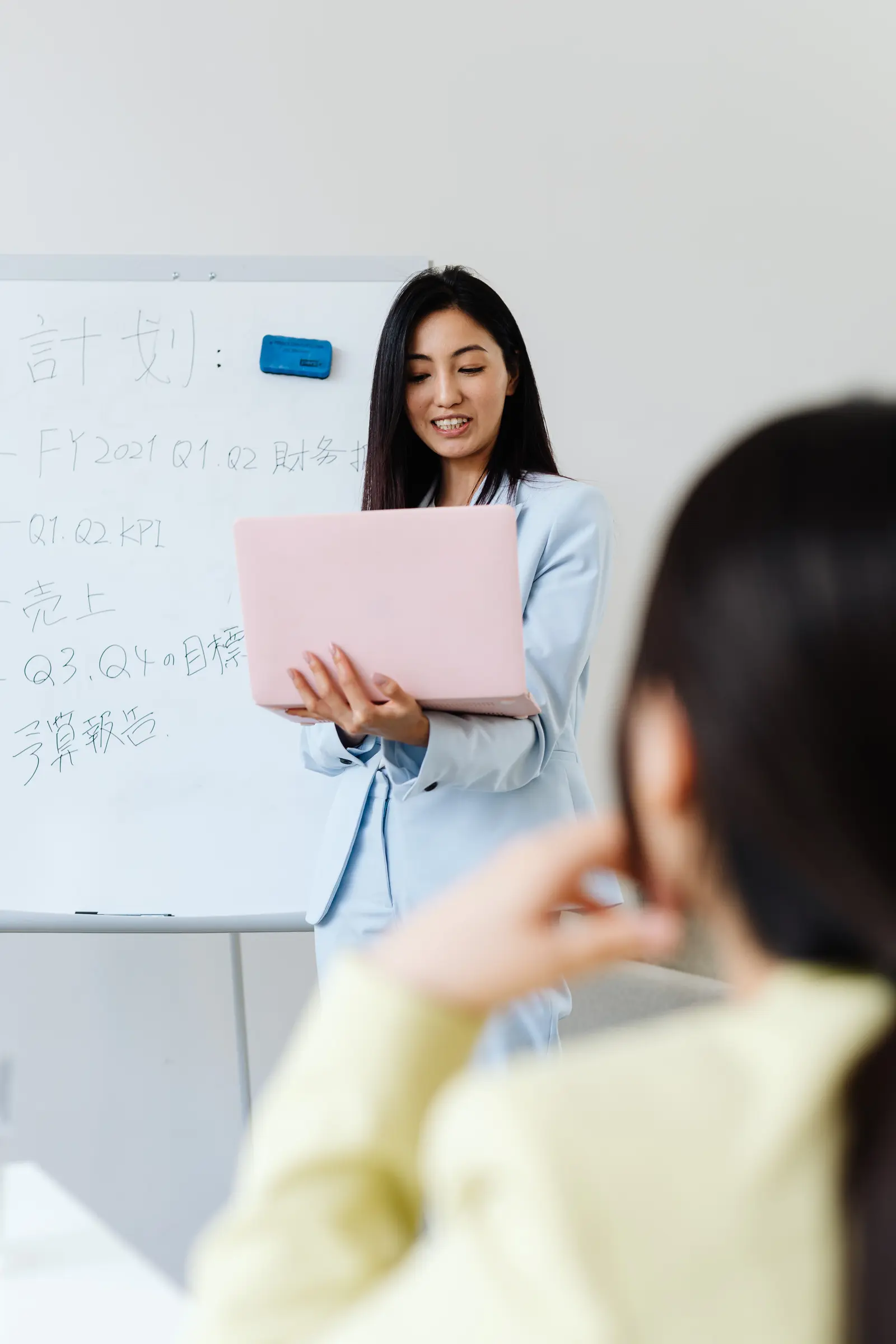 Dozentin erläutert Inhalte einer beruflichen Weiterbildung vor einem Whiteboard